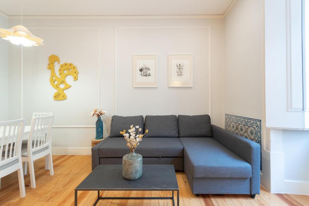 a living room with a blue couch and a table at Baixa Cozy 2BR with AC - by LU Holidays in Lisbon