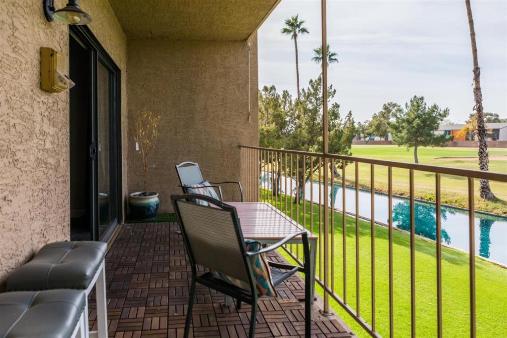 a balcony with a table and chairs next to a pool at Gated Dobson Ranch townhouse, balcony, golf views in Mesa