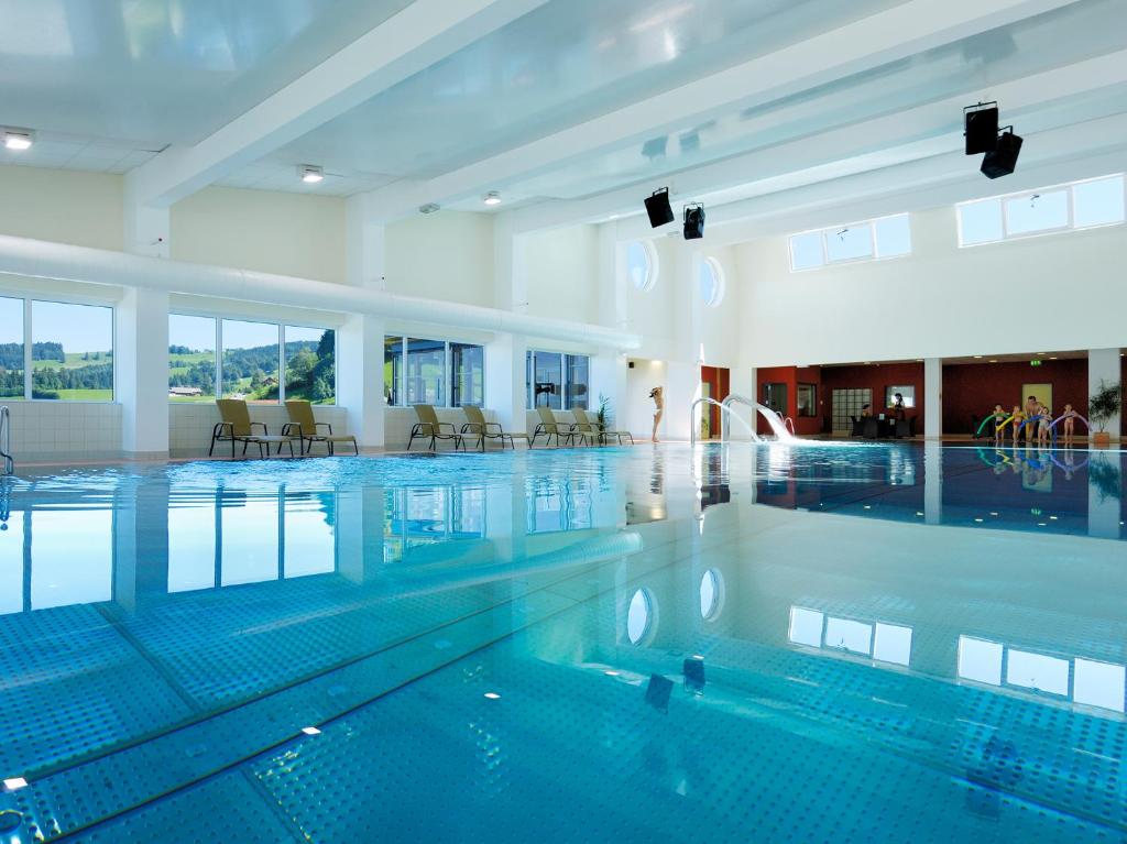 a swimming pool in a building with a swimming pool at Vitalhotel Quellengarten - Bed & Breakfast in Lingenau