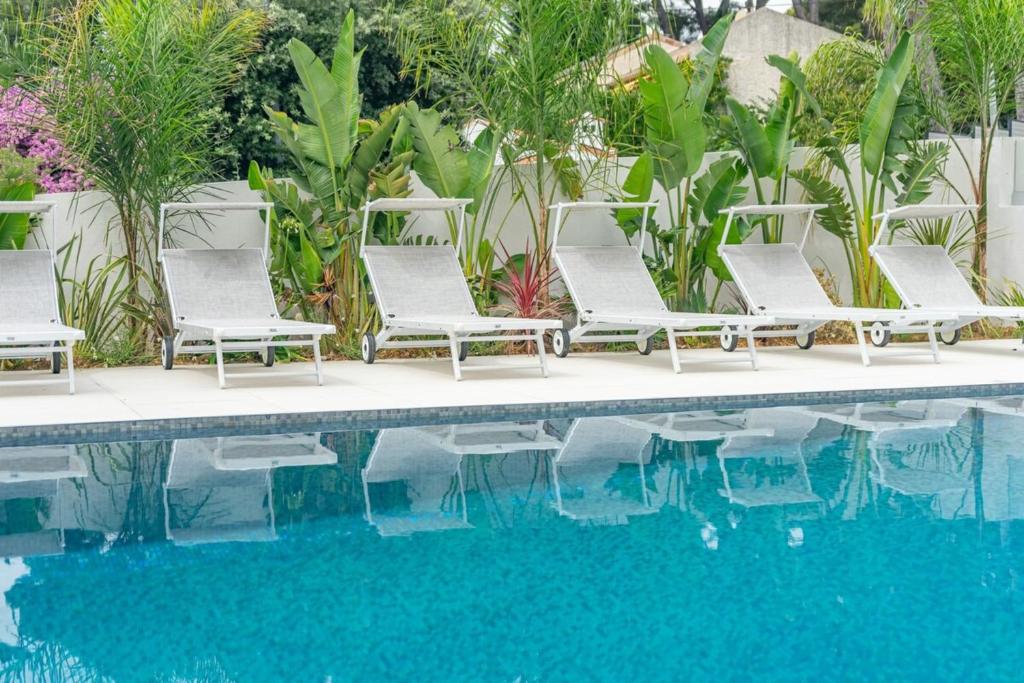 - un groupe de chaises longues à côté de la piscine dans l'établissement Giovannina N5, à Cassis