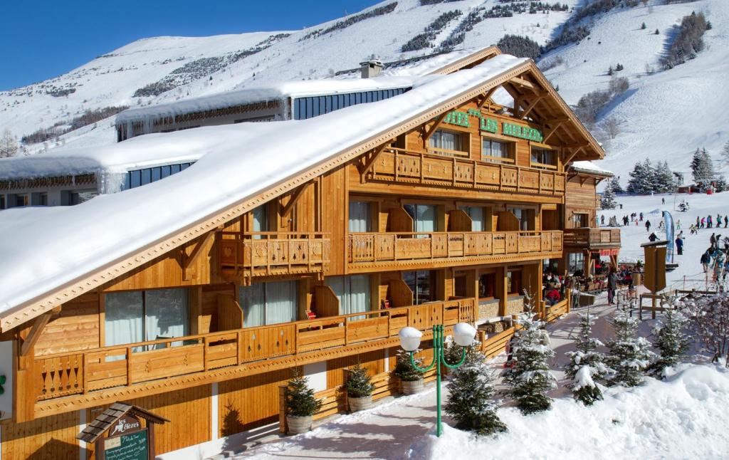 a ski lodge in the mountains with snow on it at Hotel Les Mélèzes in Les Deux Alpes
