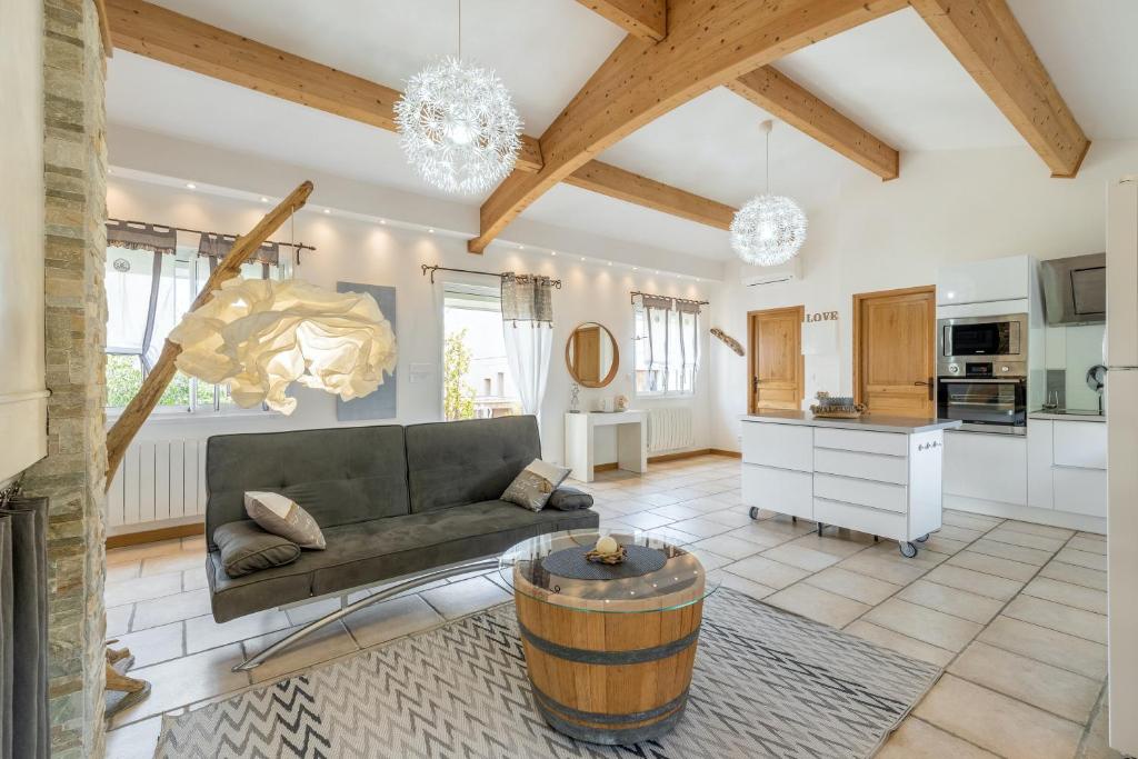 a living room with a couch and a table at Maison charmante à Poussan avec jardin privé in Poussan