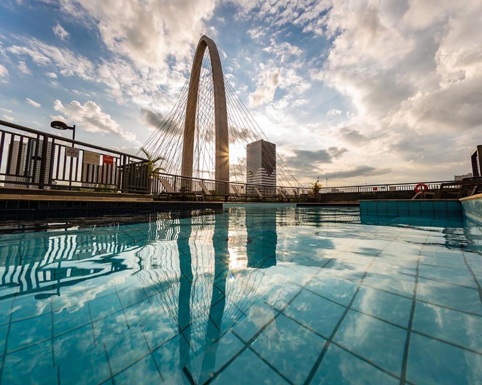 a swimming pool with the gateway arch in the background at Mercure Sao Jose dos Campos in São José dos Campos