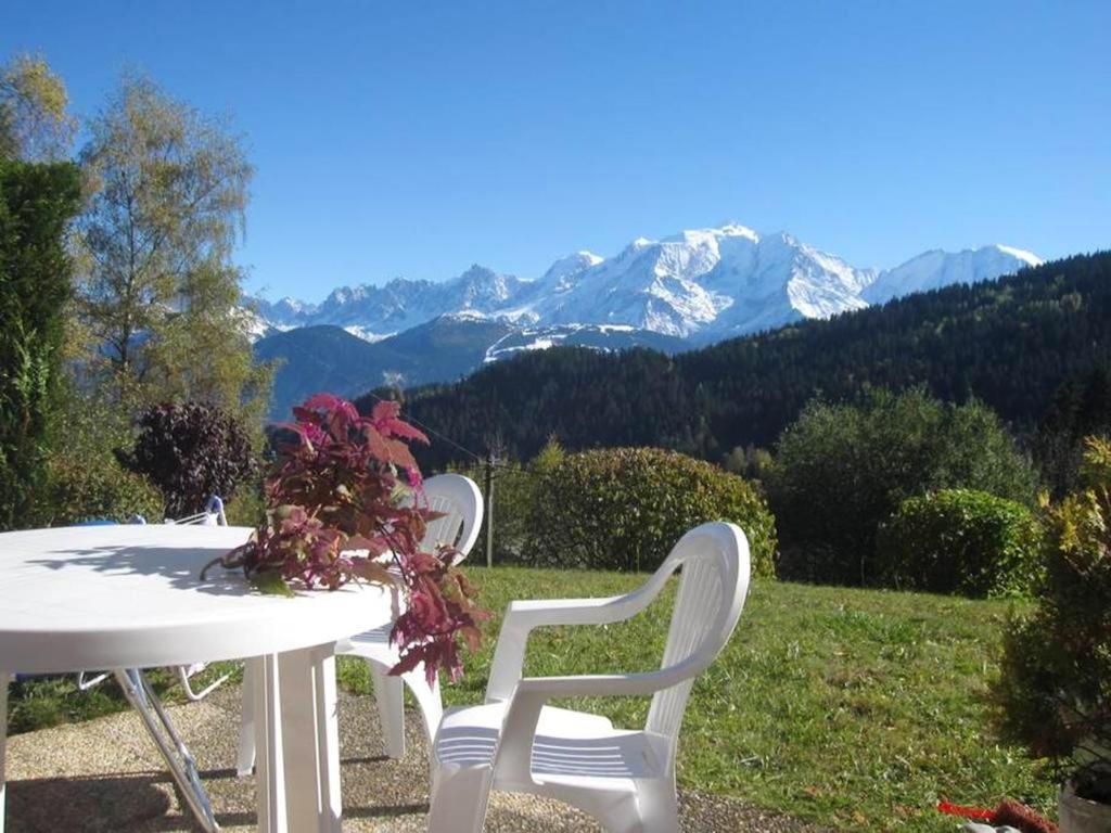 een witte tafel en stoelen met bergen op de achtergrond bij Studio avec jardin amenage et wifi a Cordon a 1 km des pistes in Cordon
