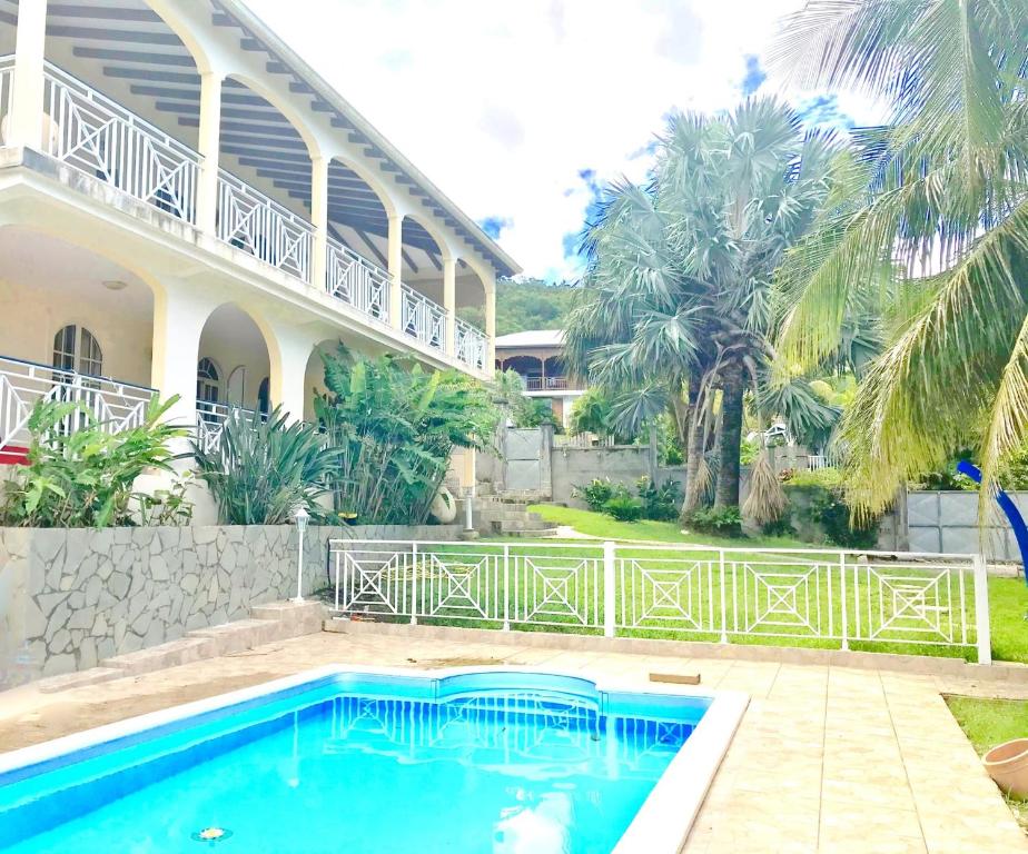 a swimming pool in front of a house at Spacieuse villa à Deshaies avec piscine privée in Deshaies