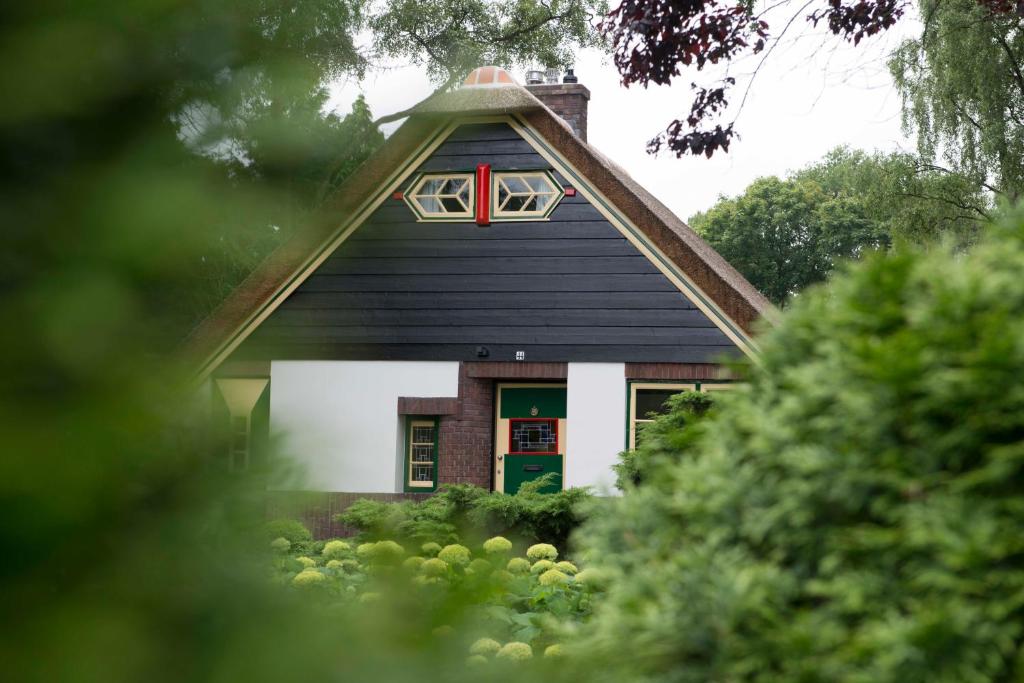 una casa con una puerta verde y una ventana roja en Huize Florinata, en Voorthuizen