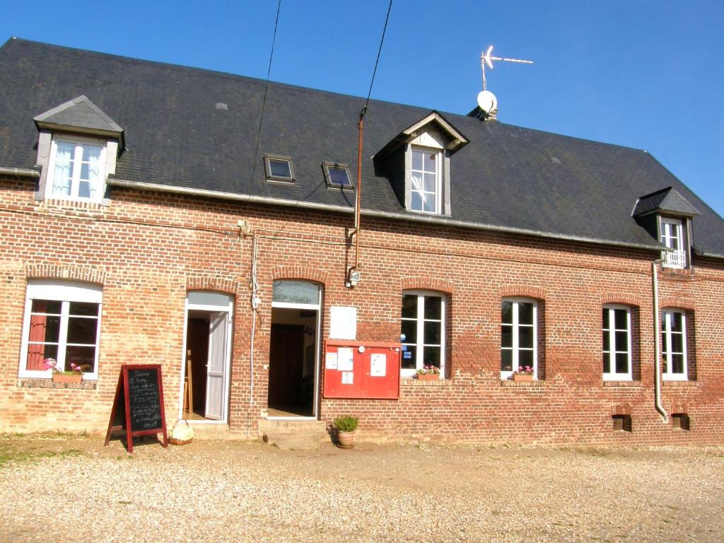 ein rotes Backsteingebäude mit schwarzem Dach in der Unterkunft Maison de 4 chambres avec jardin amenage et wifi a Berville in Berville
