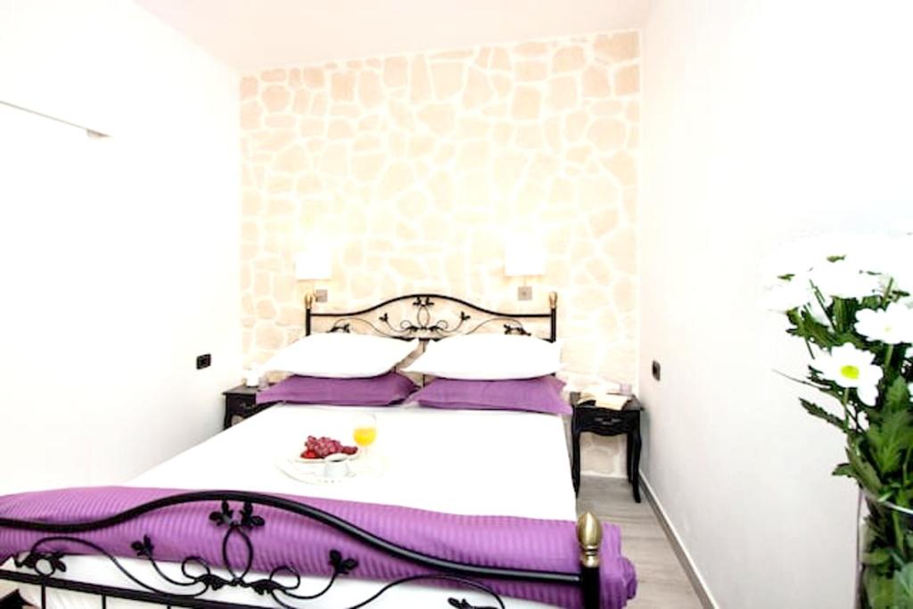 a bedroom with a large bed with purple pillows at Modern Apartment in Trogir - 70 m² - Parking Included in Trogir