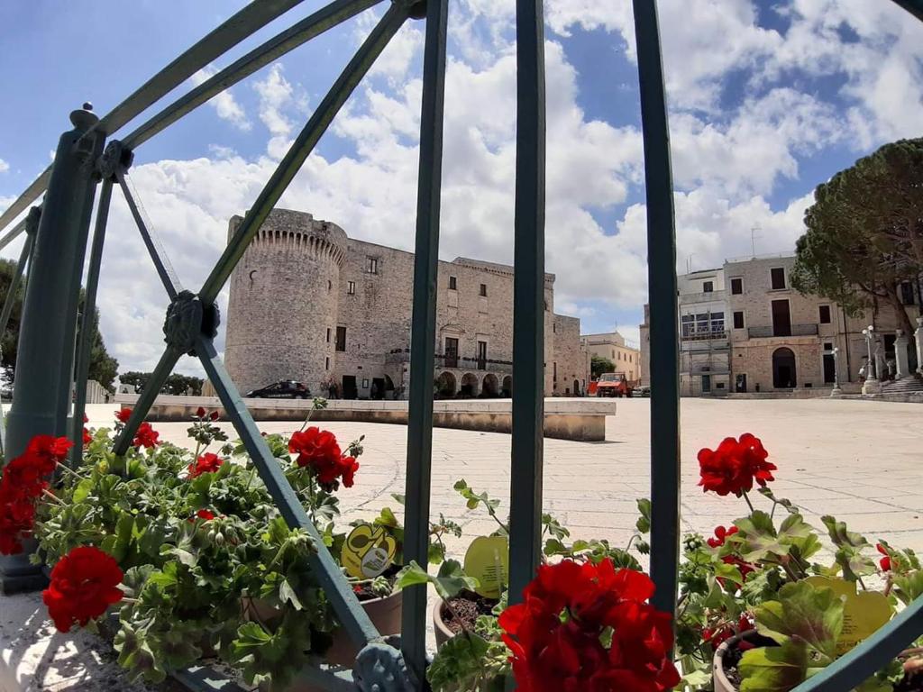 a window with red flowers in front of a castle at Fascino Antico in Conversano