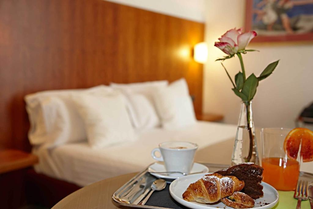 una mesa con un plato de bollería y una taza de café en Vicenza Tiepolo Hotel, en Vicenza