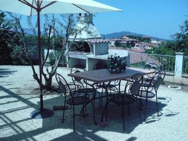 una mesa y sillas bajo una sombrilla en un patio en Monolocale Tre Mari, en Capoliveri