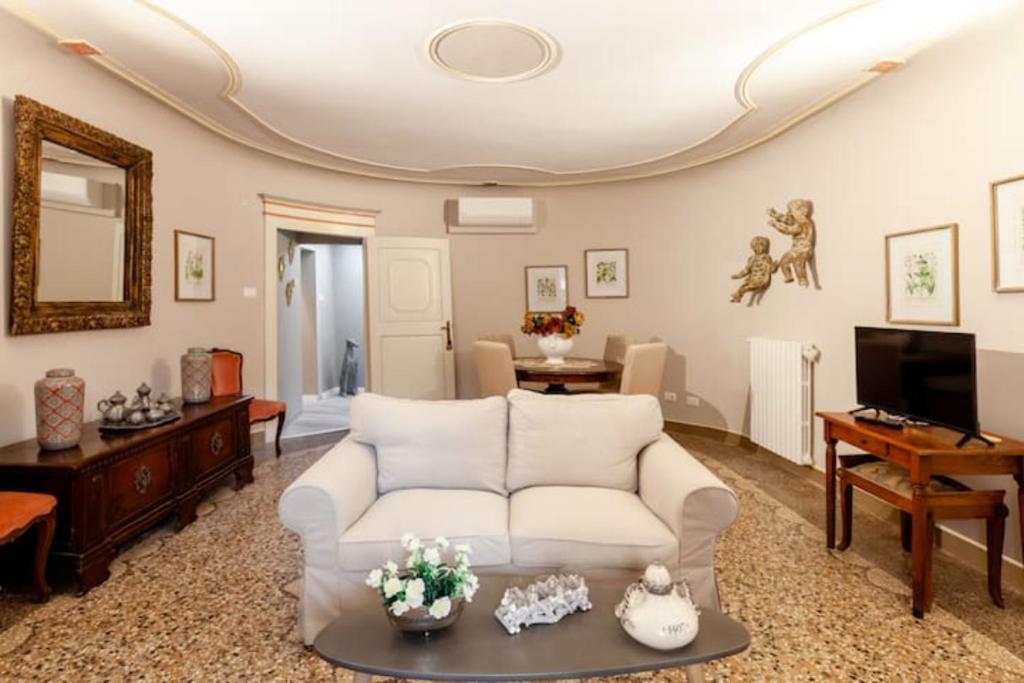 un salon avec un canapé blanc et une télévision dans l'établissement Realkasa Clavature Apartment, à Bologne