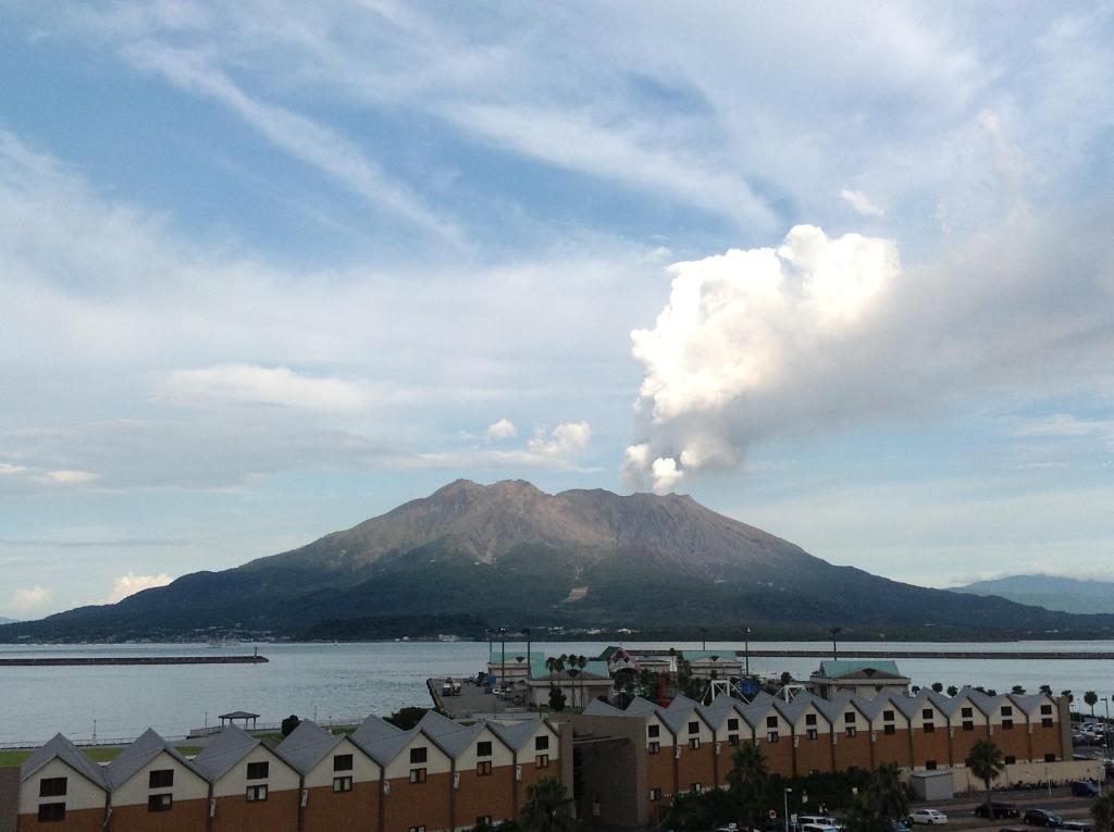 una montaña con humo saliendo de ella en la distancia en Gracias, en Kagoshima