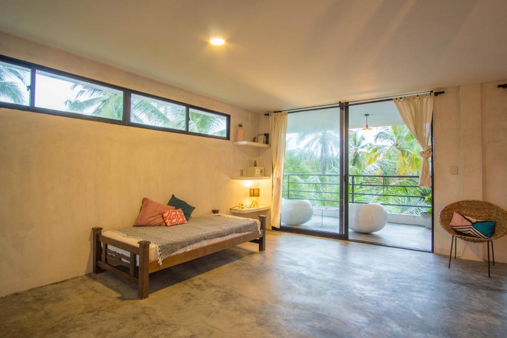 a bedroom with a bed and a large window at Casa Chapolin Boutique Guesthouse in Palomino
