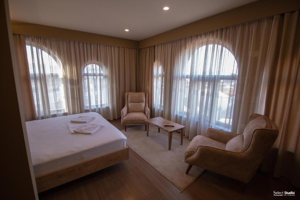 um quarto de hotel com uma cama e duas cadeiras em SAHATI Hotel & Restaurant em Korçë