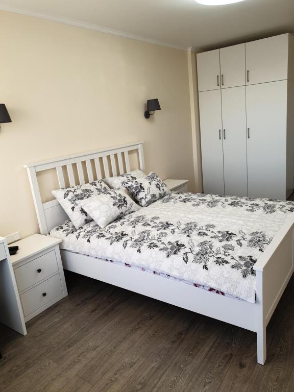 a bedroom with a white bed and a white cabinet at Swan City Apartment in Gulbene