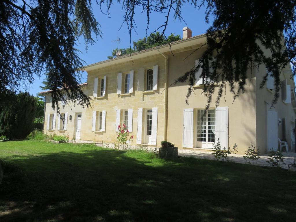 una gran casa blanca con un gran patio en Chambres d'hôtes de charme au REFUGE DU PEINTRE prés de St Emilion, en Sainte-Terre