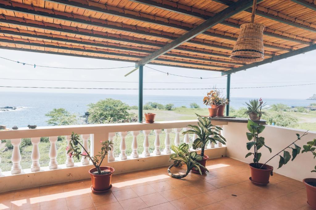 Un balcón con plantas y vistas al océano. en Casa Tabanka Apartment en Tarrafal