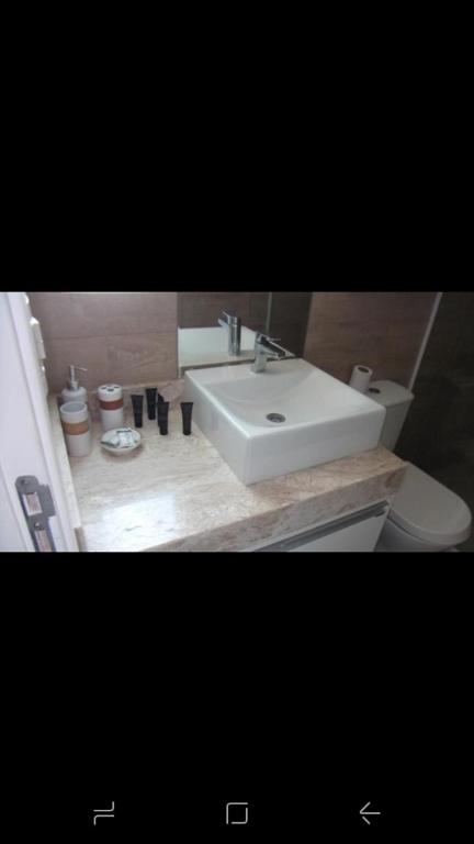 a bathroom with a white sink and a toilet at WATER FRONT in Maceió