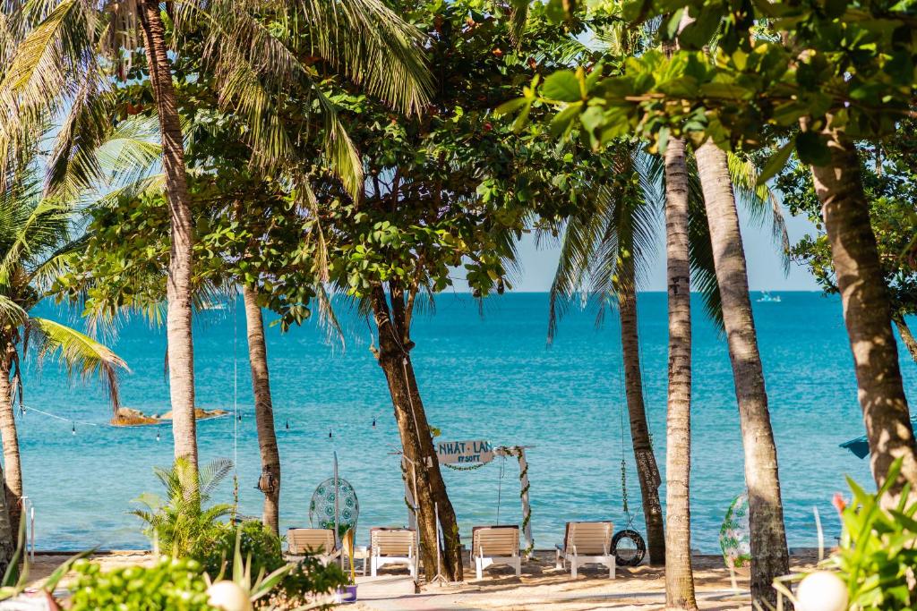 a view of the ocean from a beach with palm trees at Nhat Lan Resort in Phú Quốc