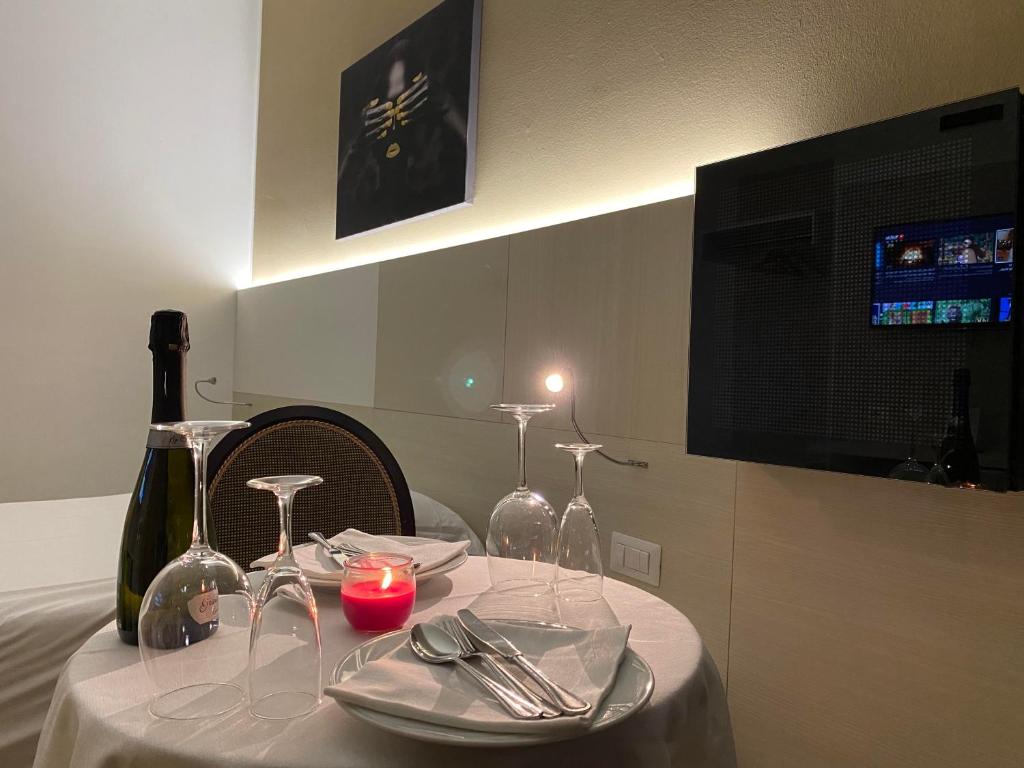 BareggioにあるHotel Ristorante Novara Expoのワイングラスとキャンドルが置かれたテーブル