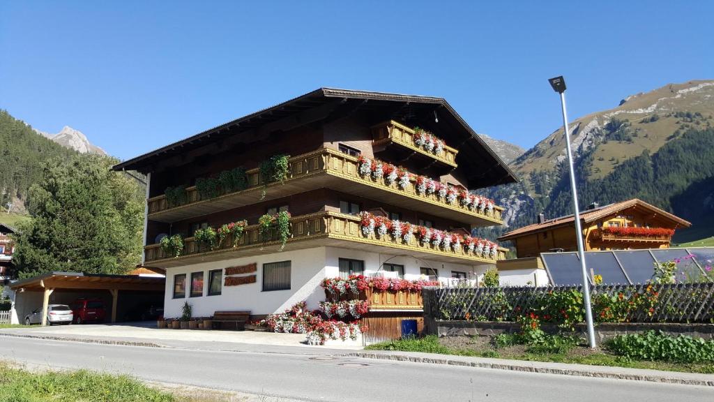 un edificio con gente sentada en sus balcones en Ferienhaus Tirolerhof en Kals am Großglockner