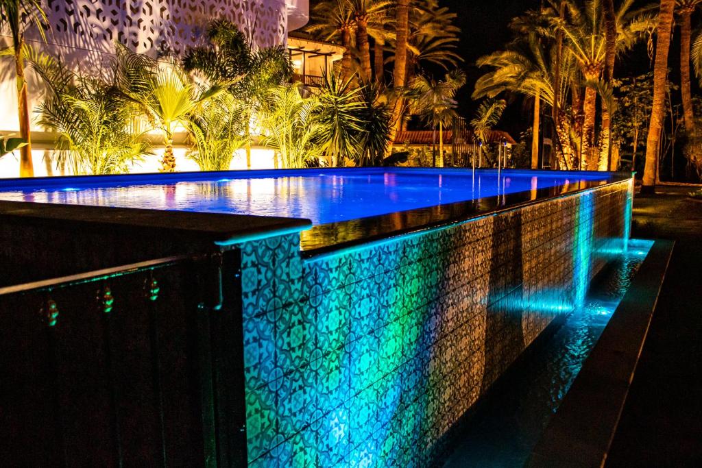 basen w nocy z niebieskimi i zielonymi światłami w obiekcie Eden Meloneras by TAM Resorts w mieście Maspalomas