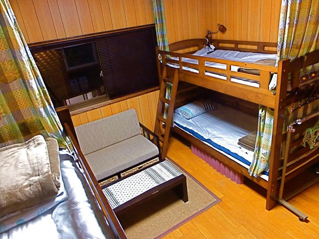 a room with three bunk beds and a couch at 4Bed Family Room Aosh ima Guesthouse Hooju Vacation STAY 13477v in Miyazaki
