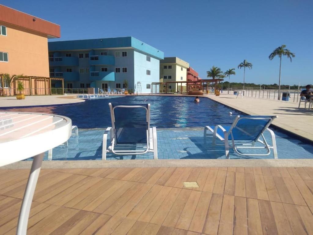 two chairs sitting next to a swimming pool at Arraial do Cabo Golden Lake Residence frente a la laguna in Arraial do Cabo