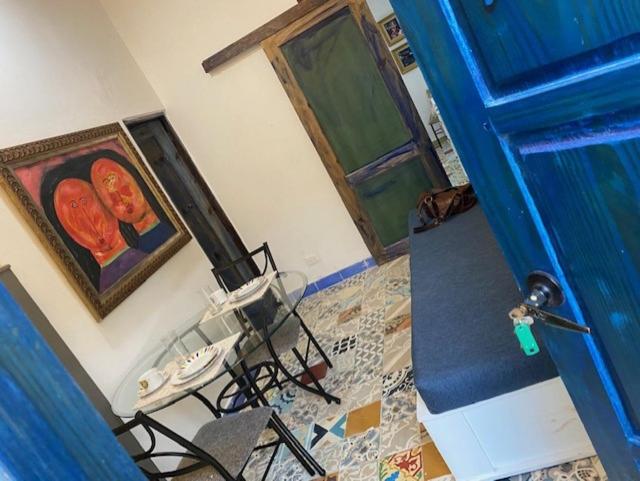 Pokój z niebieskimi drzwiami oraz stołem i krzesłami w obiekcie Chao Mamá Hostal w mieście Santo Domingo