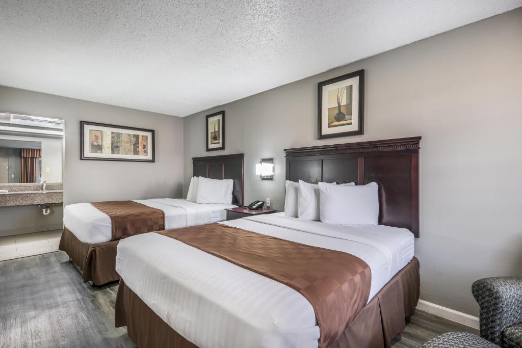 ein Hotelzimmer mit 2 Betten und einem Stuhl in der Unterkunft Americas Best Value Inn Arkadelphia in Arkadelphia