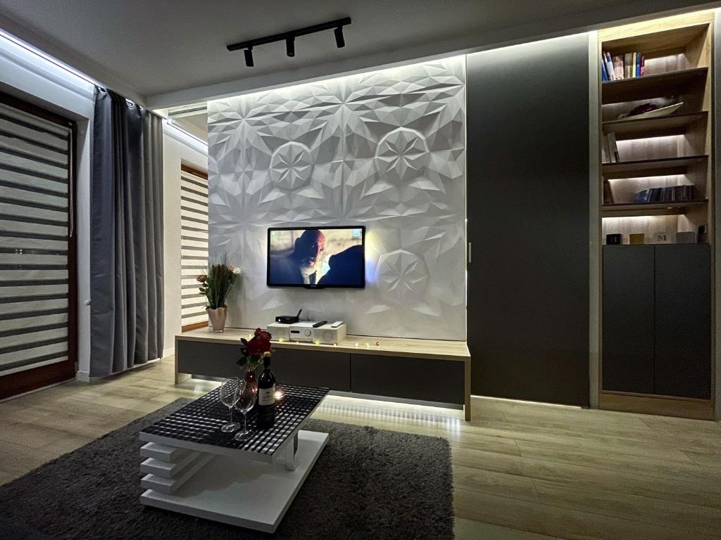 a living room with a tv on a wall at 4UApart-Apartment suite Platan Grey in Świnoujście