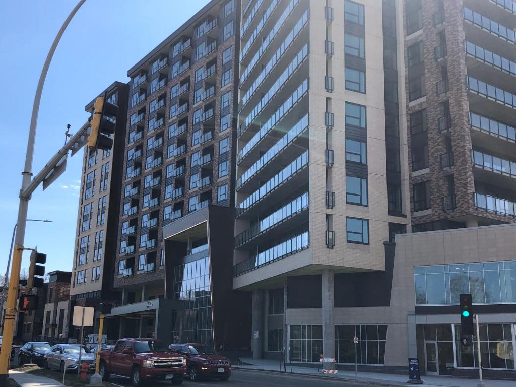 un edificio alto con coches estacionados frente a él en The Berkman en Rochester