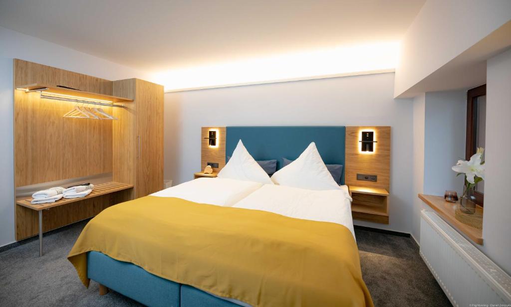 ein Hotelzimmer mit einem großen gelben und weißen Bett in der Unterkunft Landhotel Zur Guten Einkehr in Bautzen