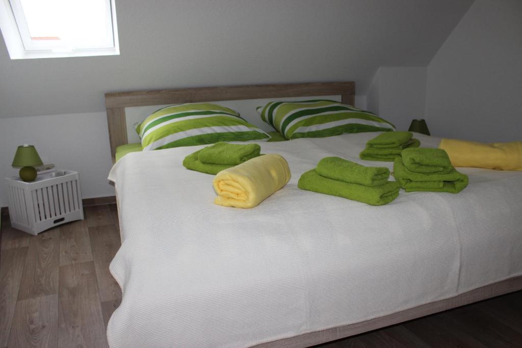 Una cama con toallas verdes y almohadas. en Ferienhaus Brücke, en Quedlinburg