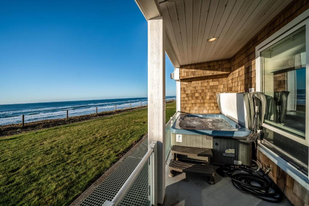 een uitzicht op het strand vanaf de veranda van een huis bij Oceanfront Contemporary in Lincoln City