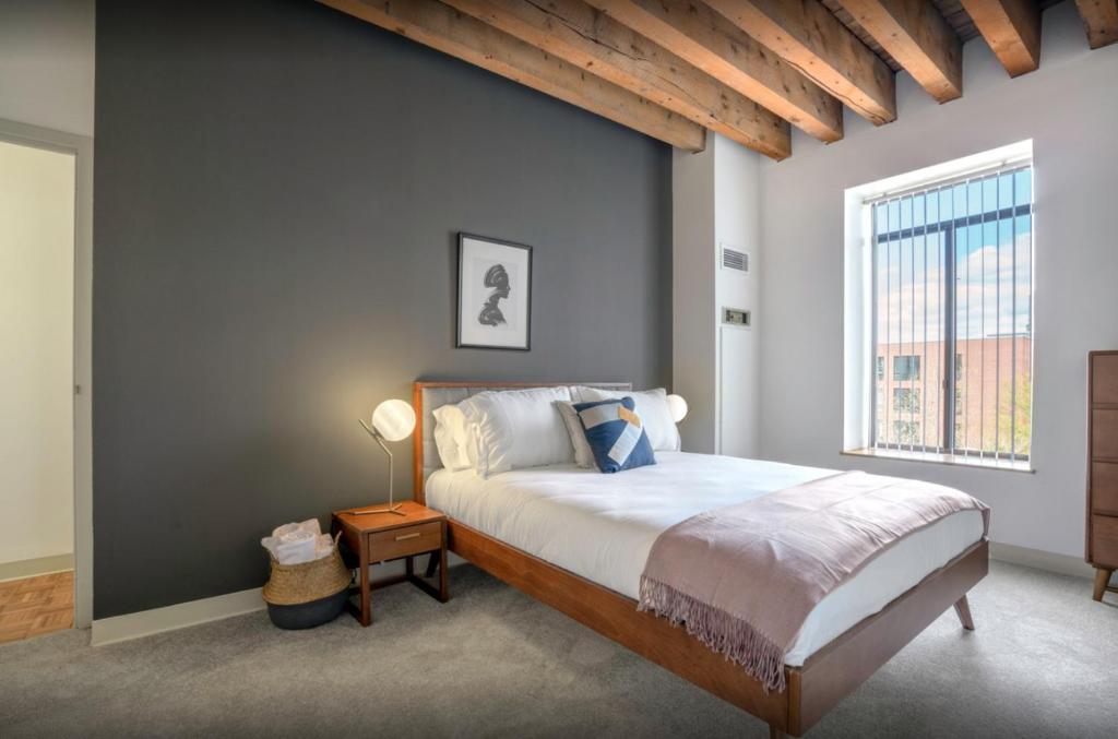 a bedroom with a bed and a large window at WaterSide Boston 30 Day Stays in Boston