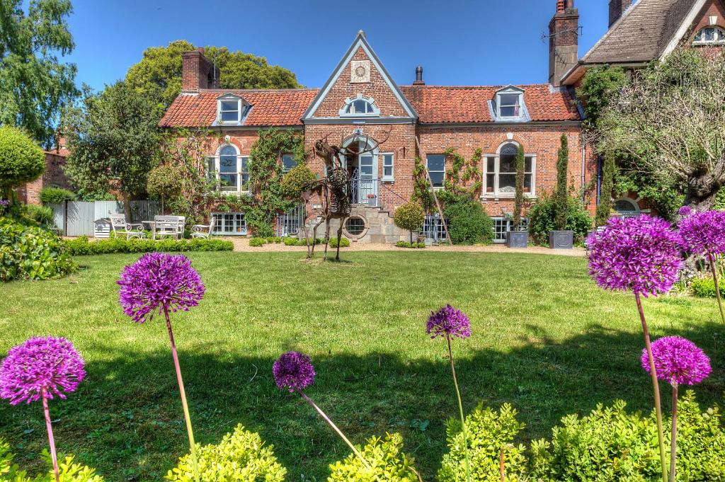 una casa con fiori viola di fronte di Strattons a Swaffham