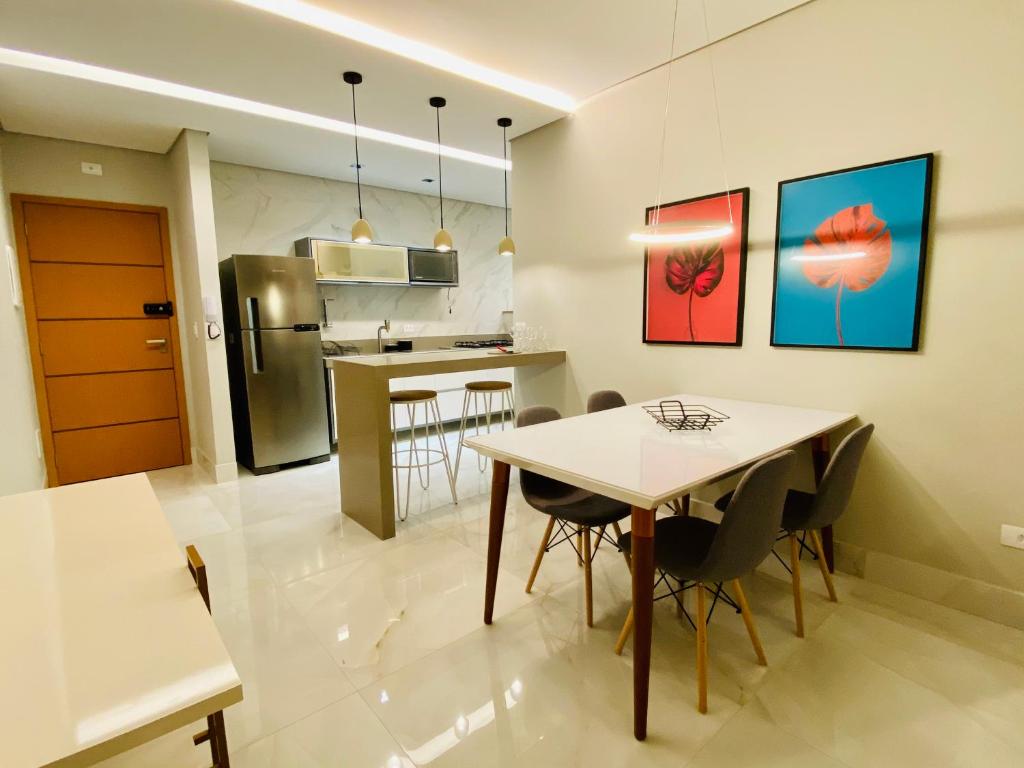 a kitchen and dining room with a table and chairs at Luxo em Ubatuba C/ Vista Montanha e Mar no Centro in Ubatuba