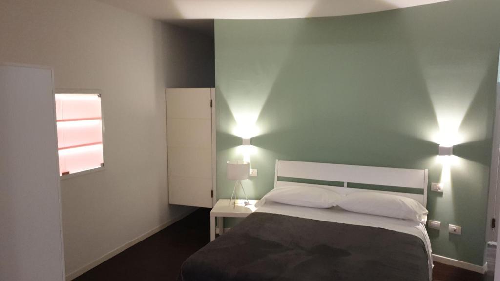 ナポリにあるResidenza Monticelliのベッドルーム1室(ベッド1台、壁に照明2つ付)