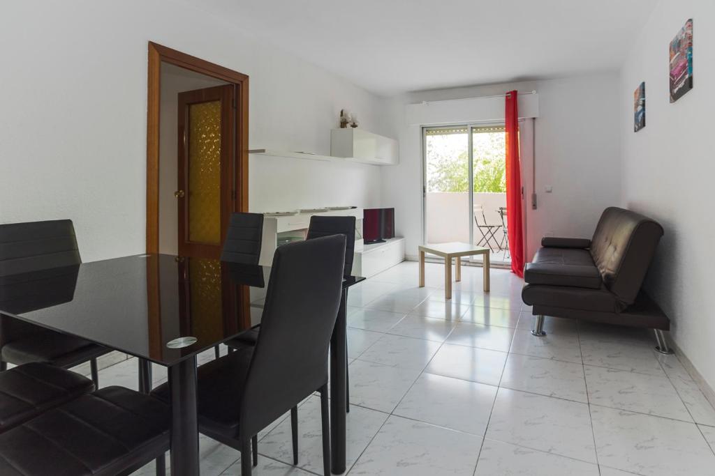 a dining room with black chairs and a dining table at Apartamentos Complutum in Alcalá de Henares