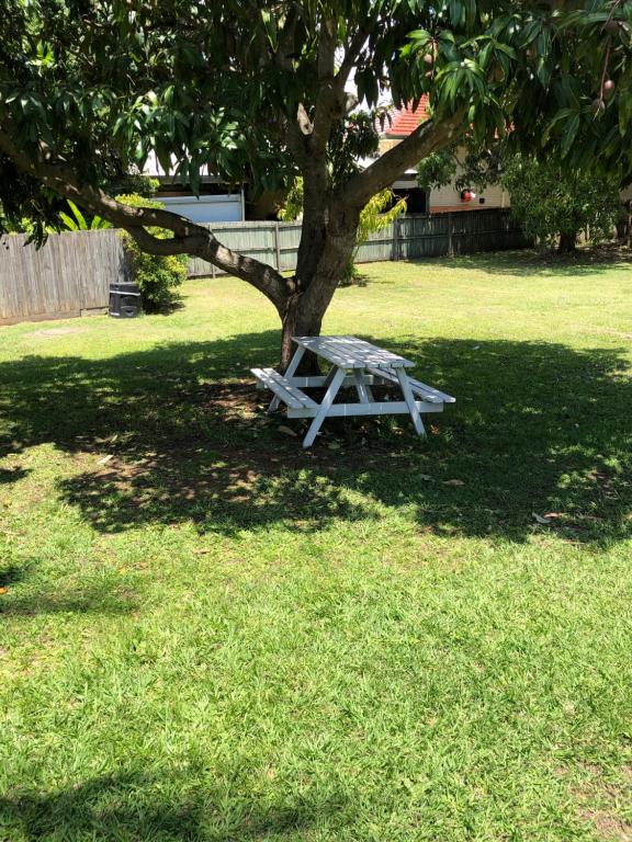 a white picnic table under a tree in a yard at Motel Mt Gravatt in Brisbane