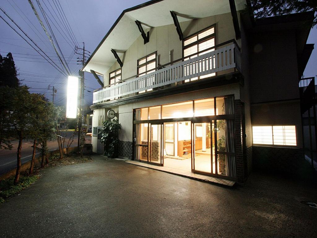 a building with its doors open on a street at Ougiya Ryokan in Hakuba