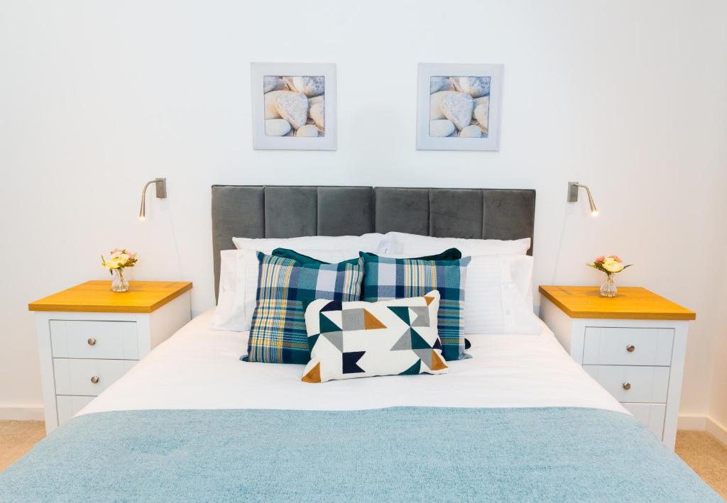 a bedroom with a bed with blue and white pillows at Absolute Stays on Grosvenor - St Albans-High Street- Near Luton Airport - St Albans Abbey Train station -Close to London- Harry Potter World - The Odyssey Cinema-Contractors -London Road-Business-Leisure in St. Albans