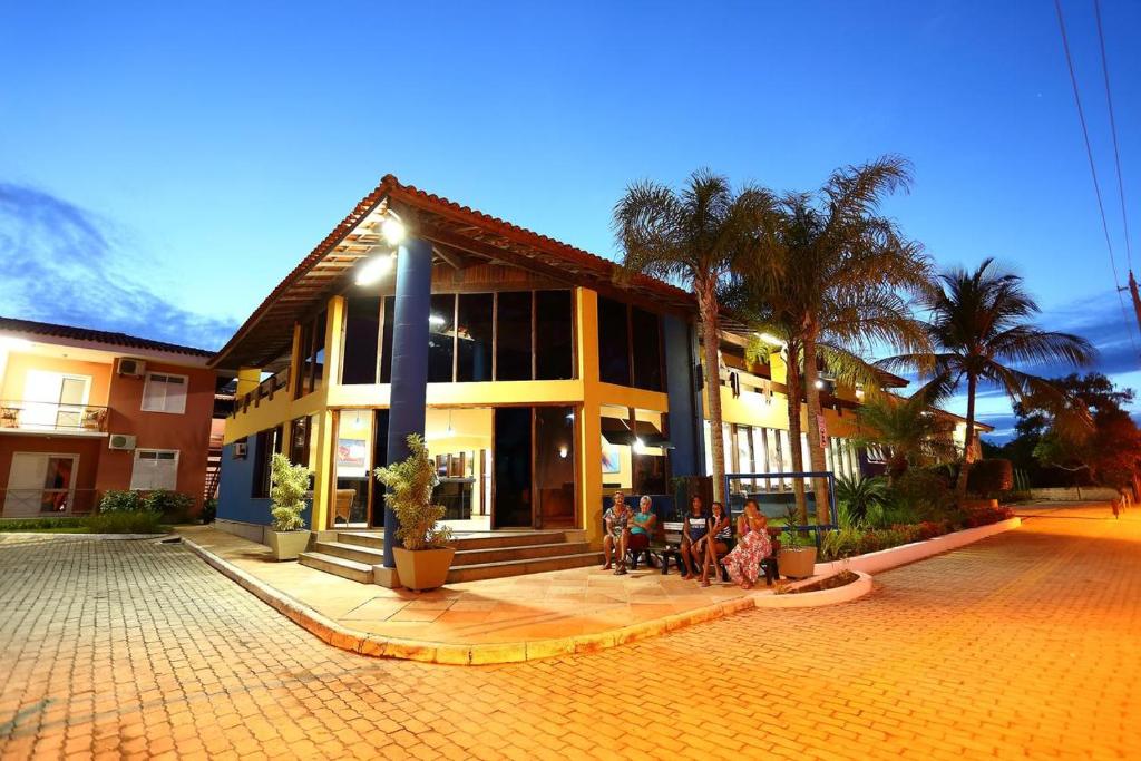 a group of people sitting outside of a building at BOULEVARD DA PRAIA Apart Hotel Beira mar in Porto Seguro