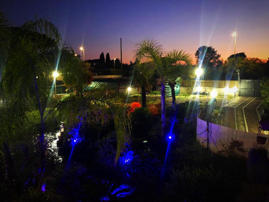 un giardino con luci blu in un parco di notte di Il Giardino Di Adriana B&B a Terracina