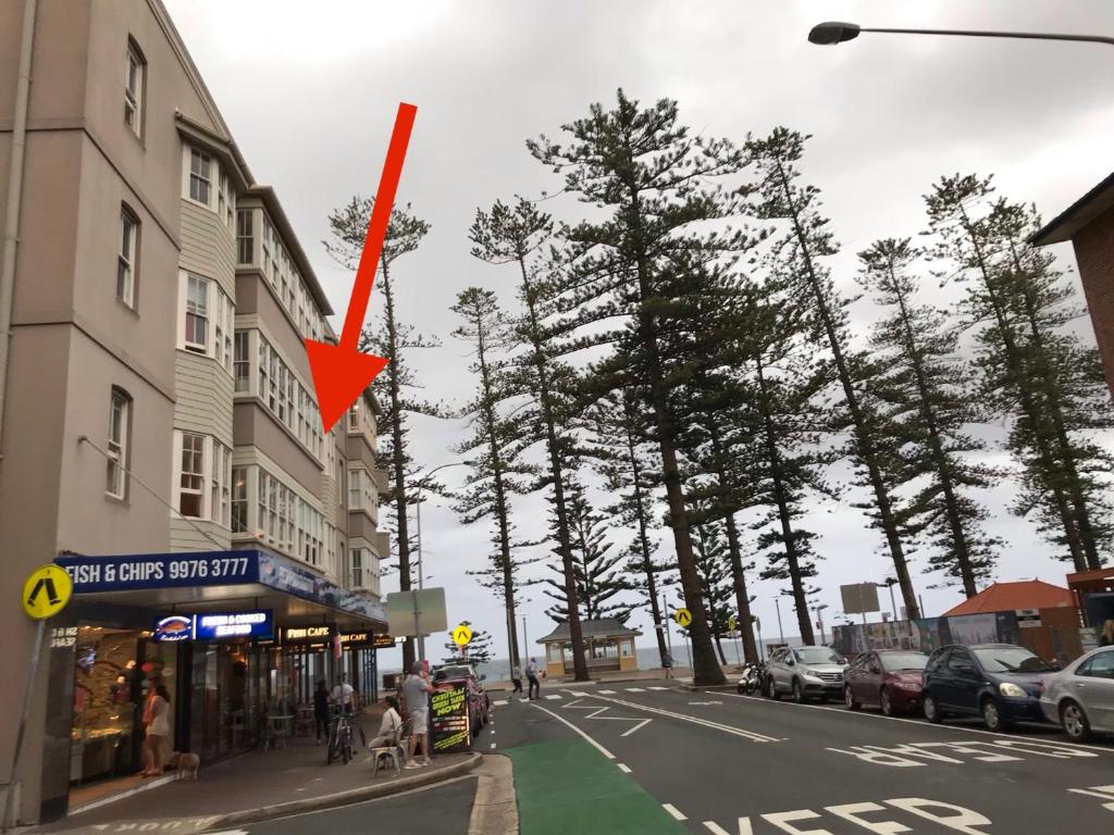 uma seta vermelha no lado de uma rua da cidade em Manly Beach Stays em Sydney