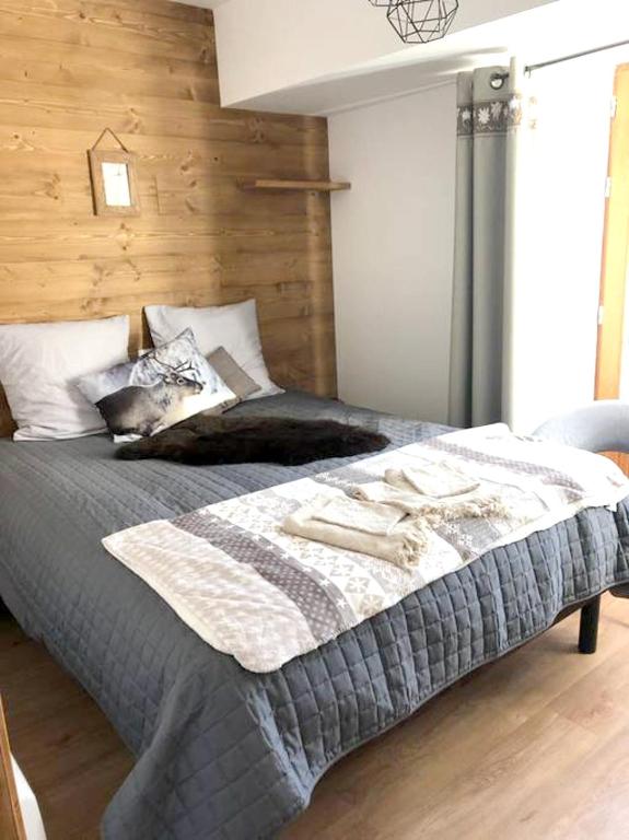 a bedroom with a large bed with a wooden wall at Appartement de 4 chambres avec jardin clos et wifi a Le Monetier les Bains in Le Monêtier-les-Bains