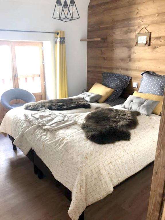 a bedroom with two beds with a furry animal on it at Appartement de 4 chambres avec jardin clos et wifi a Le Monetier les Bains in Le Monêtier-les-Bains