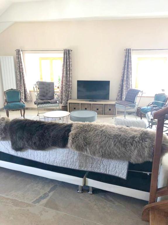 a large black dog laying on a bed in a living room at Appartement de 4 chambres avec jardin clos et wifi a Le Monetier les Bains in Le Monêtier-les-Bains